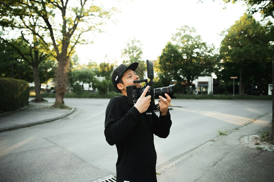Camera operator filming a live news broadcast in a studio
